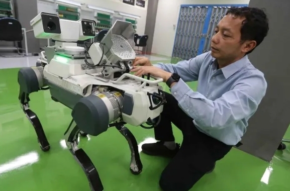 Koordinator tim robotika Institut Teknologi Sepuluh Nopember (ITS) Muhtadin memasang perangkat pada robot anjing berkaki empat