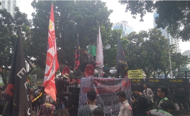 Massa ojek daring atau ojol dari Unit Reaksi Cepat (URC) menggelar aksi di kawasan Silang Monas